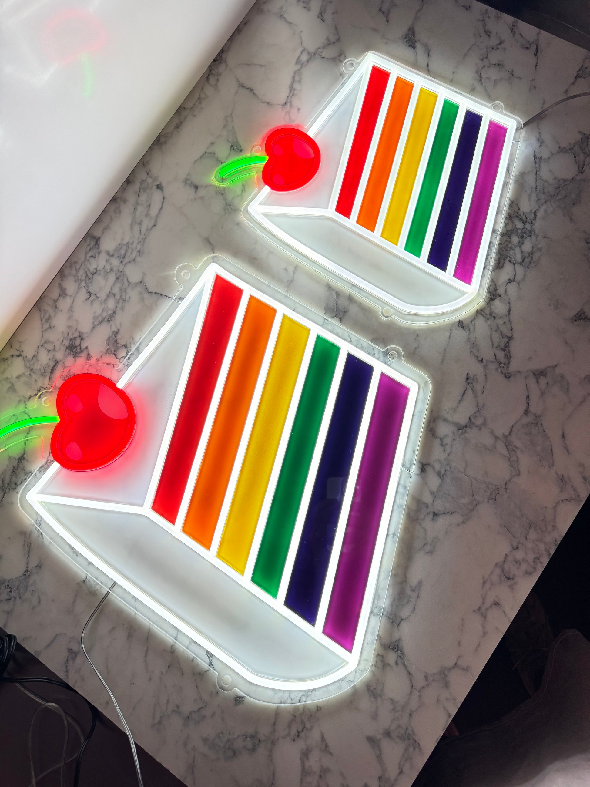 A Rainbow Cake Slice LED Neon Sign. 